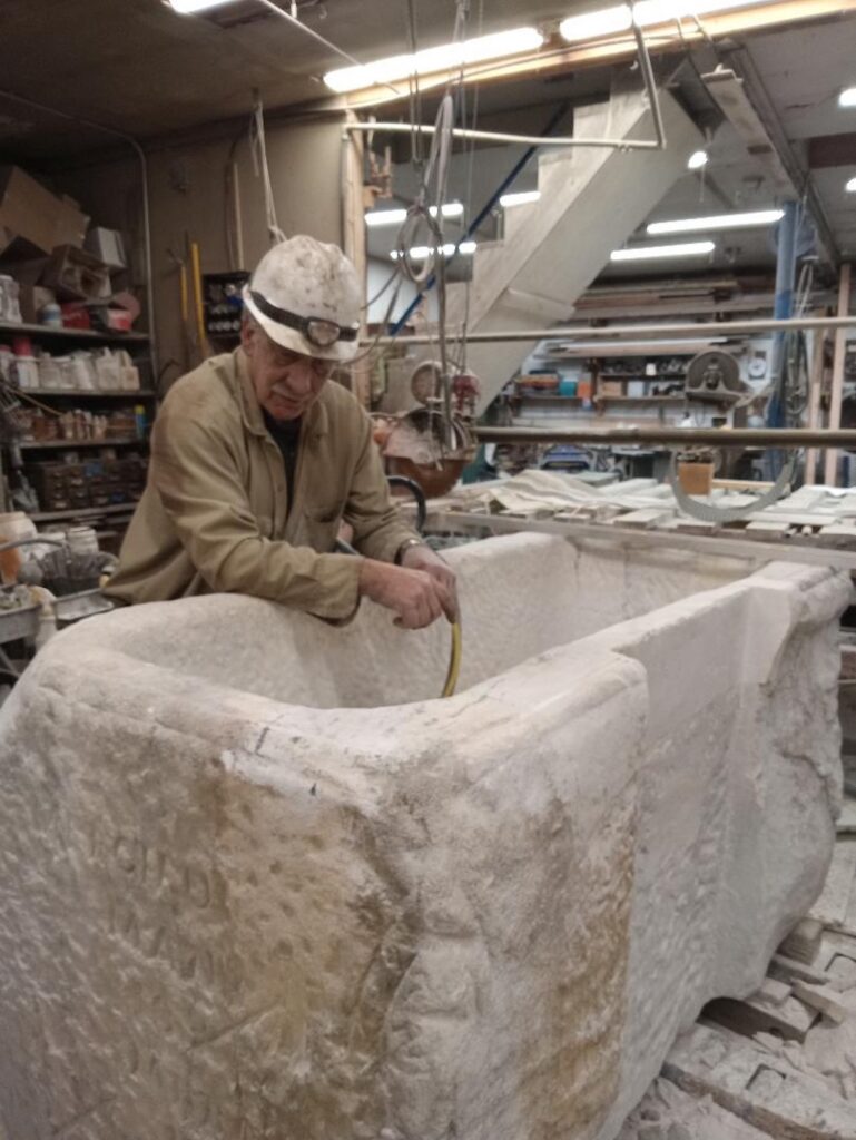 Man standing behind a stone sink